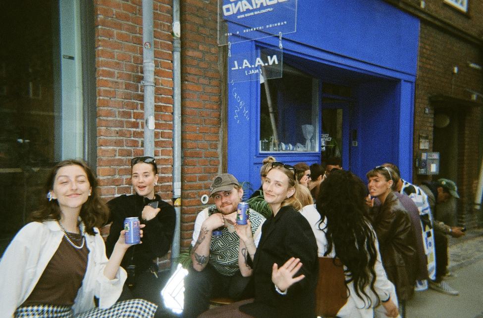 Folk der sidder om et bord med en blå væg i baggrunden